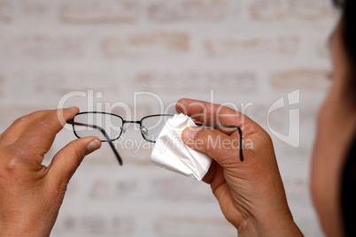 Frau putzt Brille