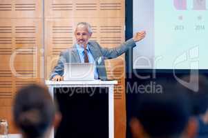 Our figures speak for themselves. A mature businessman gesturing while giving a presentation at a press conference.