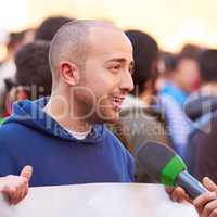 Presenting the case of the people. Shot of a protestor being interviewed at a rally.