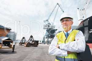 I have my business and i am proud. Portrait of a dock worker standing at the harbor amidst shipping industry activity.