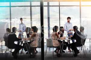 Its about getting their input. Shot of a businessman giving a whiteboard presentation to a group of colleagues in a boardroom.