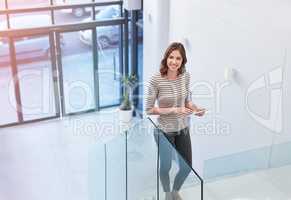 Fast internet speed for a fast business pace. Shot of a young businesswoman using a digital tablet on the stairs in a modern office.