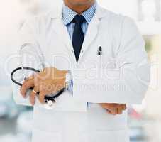 Committed to helping you stay healthy. Cropped shot of a doctor holding a stethoscope and folding his arms.