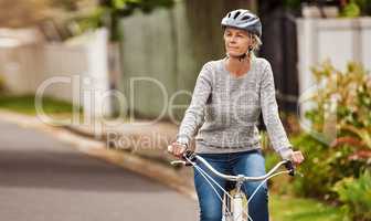 Where should I go now. Cropped shot of a cheerful senior woman riding on a bicycle by herself outside in a suburb.