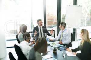 Working through the meeting agenda like pros. Shot of a team of executives having a formal meeting in a boardroom.