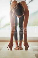 Fitness is a way of life. Full length shot of a young woman practicing yoga at home.