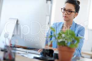 New generation of serious professionals. Tilted view of a beautiful young creative woman working on her pc at her desk.