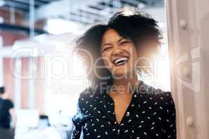Working here is so much fun. Portrait of an attractive young female designer laughing and in good spirits at the office.
