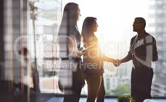 Lets move business forward together. Cropped shot of businesspeople shaking hands in an office.