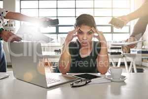 Work overload. Shot of a stressed out businesswoman surrounded by colleagues needing help.