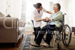 The best care you could hope for. Shot of a smiling caregiver helping a senior woman in a wheelchair at home.