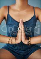 Zen. Cropped shot of a young woman meditating against a grey background.