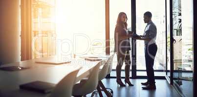 Sharing valuable contributions. Shot of two businesspeople having a discussion in an office.