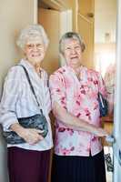 Lets go paint the town red. Portrait of two elderly woman closing the door before they leave to go out.