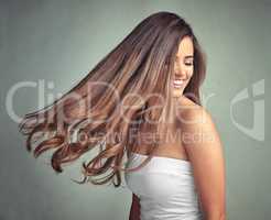 Natural beauty needs no introduction. Studio shot of a beautiful woman with long locks posing against a grey background.