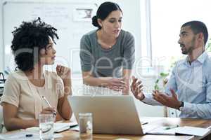 Talking their way to innovative concepts. Shot of a group of professionals using wireless technology during a meeting.