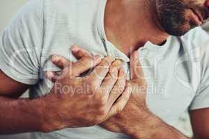 Chest pain is the worst. Shot of a unrecognisable young man holding his chest in discomfort with his hands due to pain in that area.