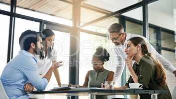 Realising their collective goal. Shot of a group of colleagues working together in an office.