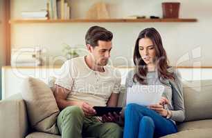 Getting a good grasp on their home finances. Shot of a young couple going through their paperwork together at home.