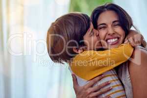 The kind of love that cant be described, only felt. Shot of an adorable little boy affectionately kissing his mother at home.