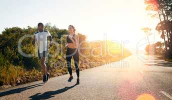 Taking their run out on the open road. Shot of a fit young couple going for a run outdoors.