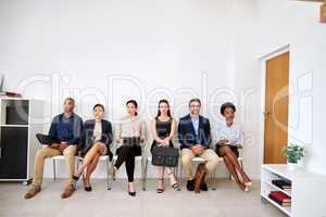 Its a long wait, but itll be worth it. Shot of a group of businesspeople seated in line while waiting to be interviewed.