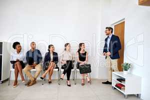 So sorry to keep you waiting. Shot of a group of businesspeople seated in line while waiting to be interviewed.