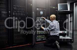 Hes well-versed in all things IT. Rearview shot of an IT technician repairing a computer in a data center.