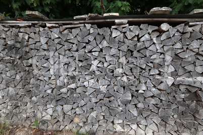 Dry firewood is evenly stacked in the woodpile