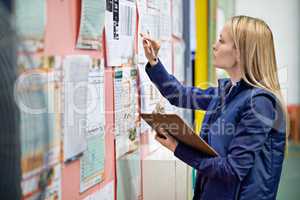 Checking the shipping calender. Shot of a woman at work in a storage warehouse.
