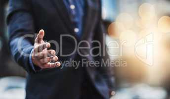 Lets make this merger happen. Closeup shot of an unrecognizable businessman extending a handshake in the city.