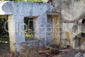 Historic building ruins with dirt and grass growing. Old ancient house or home broken and damaged. Open window in thick stone vintage design or architecture. Weathered antique farmhouse or building