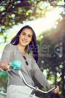 You cant be sad while riding a bicycle. Portrait of an attractive young woman riding her bicycle outside.