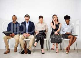 Eager to make a good impression. Shot of a group of businesspeople seated in line while waiting to be interviewed.