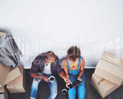 Browsing through decor ideas with some coffee. Shot of an attractive young couple moving house.