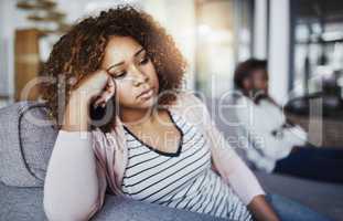 Shes in no mood to even think about reconciling. Shot of a young woman looking despondent after having a fight with her boyfriend at home.