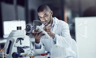 Organizing the test results. Shot of a scientist recording his findings on a digital tablet.