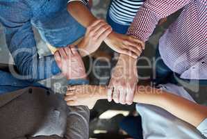 United we stand. Top view of co-workers hand put together in an expression of unity and team spirit.