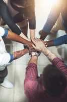 Taking it to the top together. Cropped shot of a work group joining hands in solidarity.