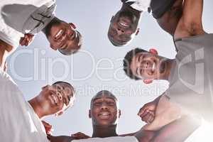 Portrait of sporty men from below joining in huddle for support and unity. Group of cheerful friends and motivated athletes collaborating together in solidarity as a happy team and diverse community