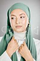 Closeup of beautiful muslim woman posing in a studio with a green hijab. Headshot of a stunning confident arab model isolated against a grey background. Zoomed in on young fashionable middle eastern