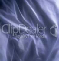 Top view of blue fabric background. Wrinkled natural linen material. Smooth satin or velvet sheets with gentle folds. Closeup texture of luxurious grey cloth. Abstract dark silk patterns or creases