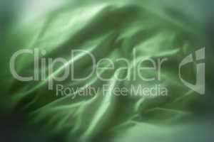 Green satin fabric textures. Velvet smooth material with elegant folds. Closeup texture of natural green luxury cloth. Abstract background of green silk patterns or creases