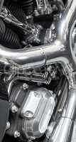 Closeup of an old classic retro style motorbike with full shiny chrome finish. Detail view of the engine and frame on an vintage motor cycle with black cylinders, shiny chrome pipes and bolts