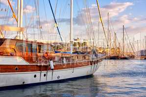 Group of boats docked in a harbor of Bodrum in Turkey at sunset. Scenic view of sailing yachts in cruise port and bay at dusk. Empty dockyard in Aegean sea in evening. Tourism abroad, overseas
