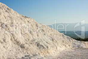Cotton castle area with carbonate mineral after flowing thermal spring water. Landscape of travertine pools and terraces in Pamukkale Turkey. Traveling abroad, overseas for holiday, vacation, tourism