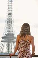 Rearview shot of a young woman admiring the view from the balcony of an apartment overlooking The Eiffel Tower in Paris, France