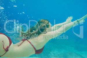 Beautiful woman swimming underwater on paradise beach freedom wellbeing lifestyle summer vacation wanderlust