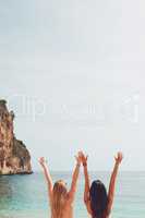 Adventure beautiful friends arms raised on paradise beach on destination summer wanderlust vacation