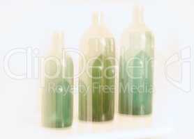 Artistic design of old glass bottles with blury motion effect, isolated on white background. Abstract blurred colorful light on three green glass bottles. Long exposure effect of dreamy drunk vision